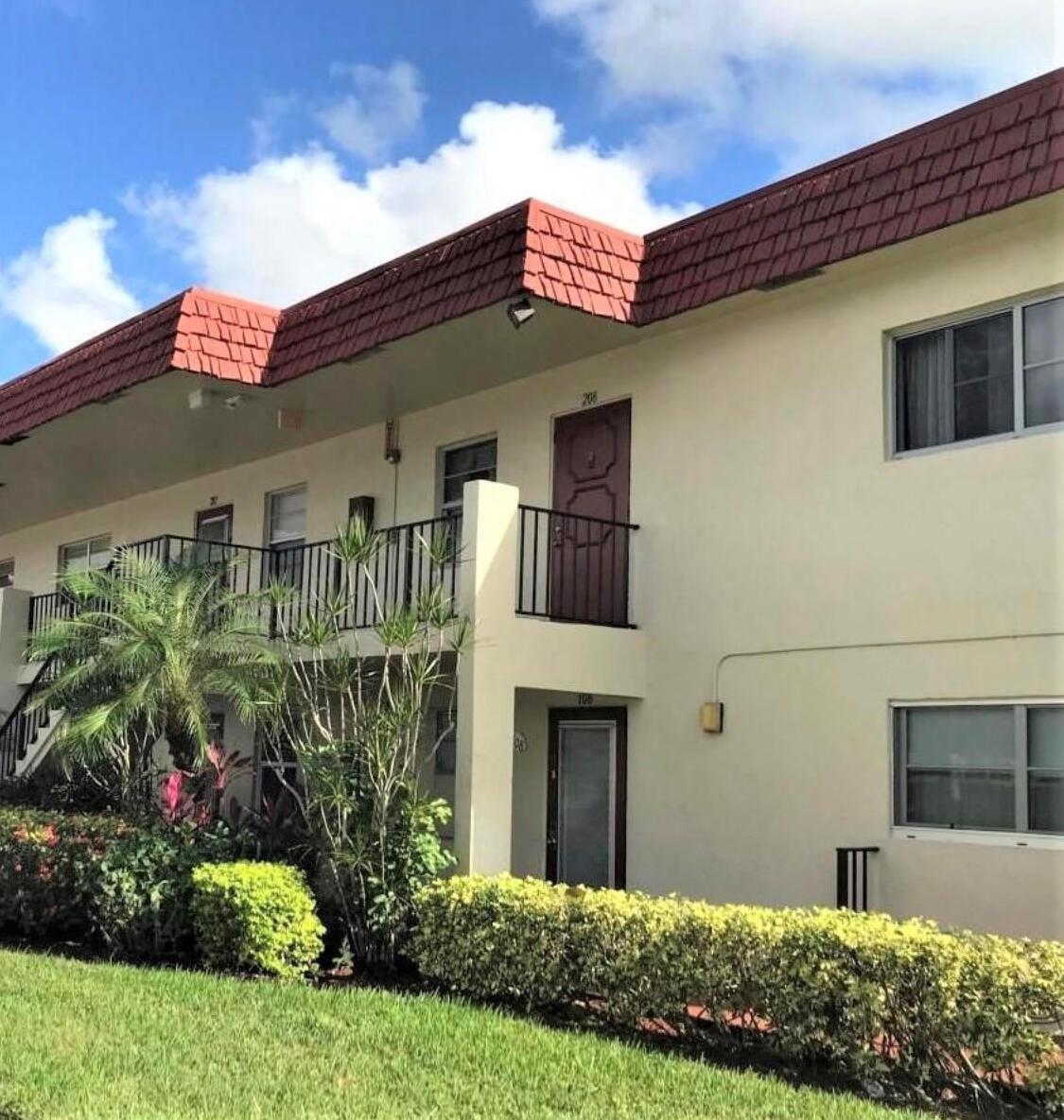 A two-story apartment building exterior with a red tiled roof and a second-floor balcony — 19 Abbey Lane # 206, Delray Beach FL 33446, DELRAY BEACH, FL