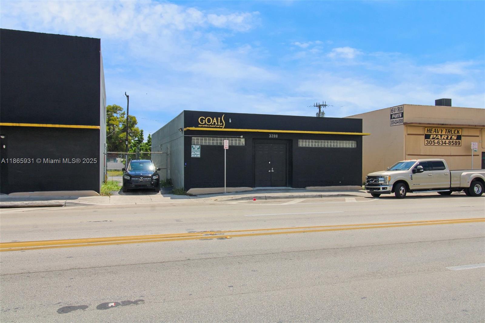 A black commercial building with a yellow trim sits between a vacant lot and a warehouse — 3270 NW 36th St, Miami FL 33142, MIAMI, FL