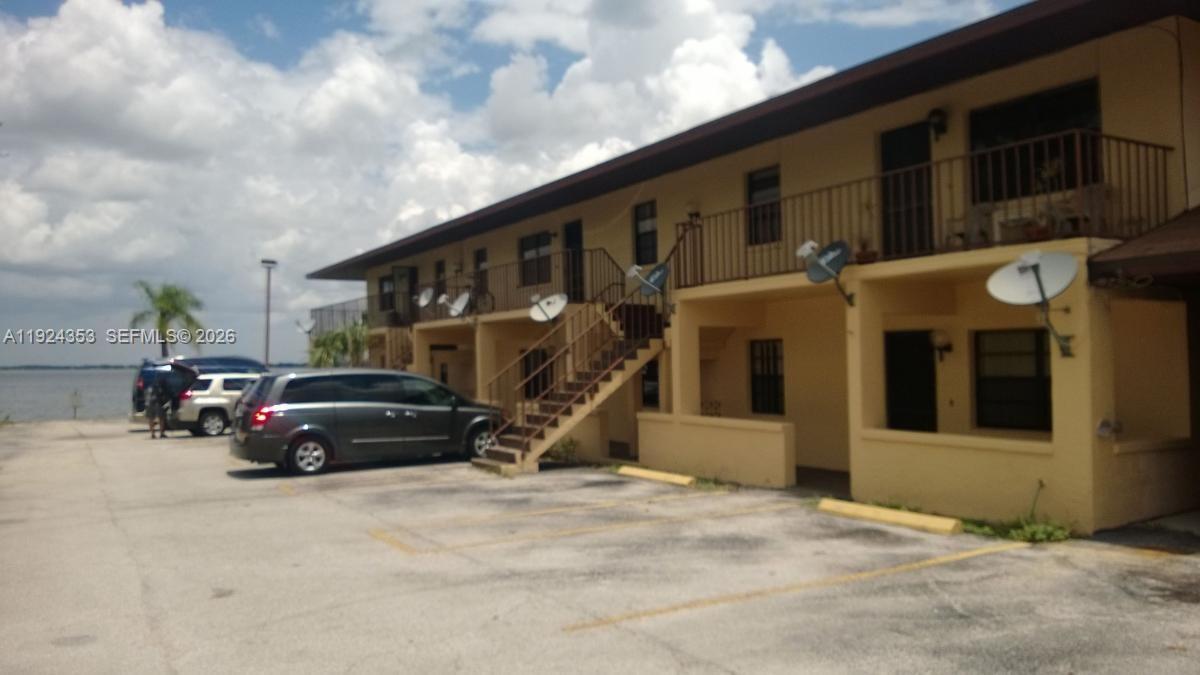 A two-story yellow apartment building with an exterior staircase and a parking lot — 1025 LAKEVEIW DRIVE, Sebring FL 33870, SEBRING, FL
