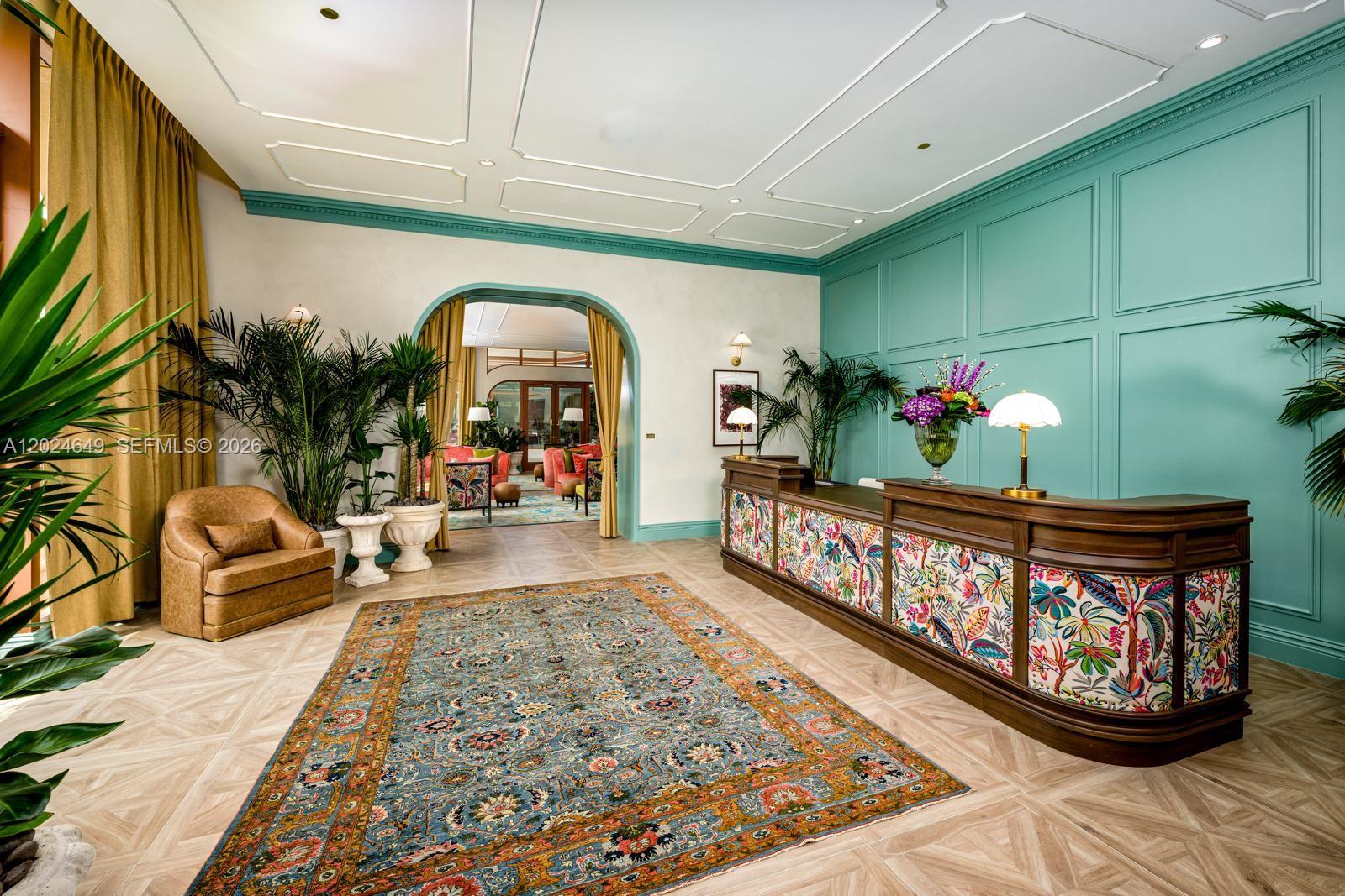 A hotel lobby features a floral-patterned reception desk, a patterned rug, and teal wall paneling — 2700 NW 2nd Ave # 233, Miami FL 33127, MIAMI, FL