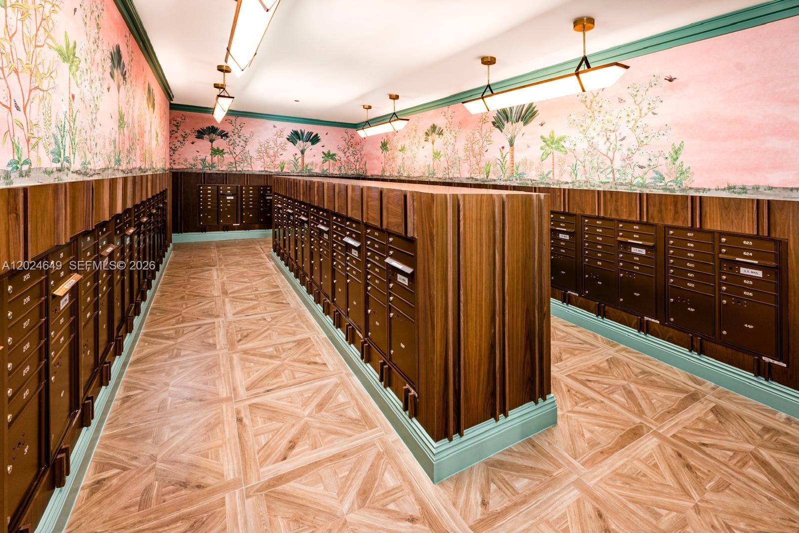 A mailroom features rows of wooden mailboxes, patterned wallpaper, and light wood-look tile flooring — 2700 NW 2nd Ave # 233, Miami FL 33127, MIAMI, FL