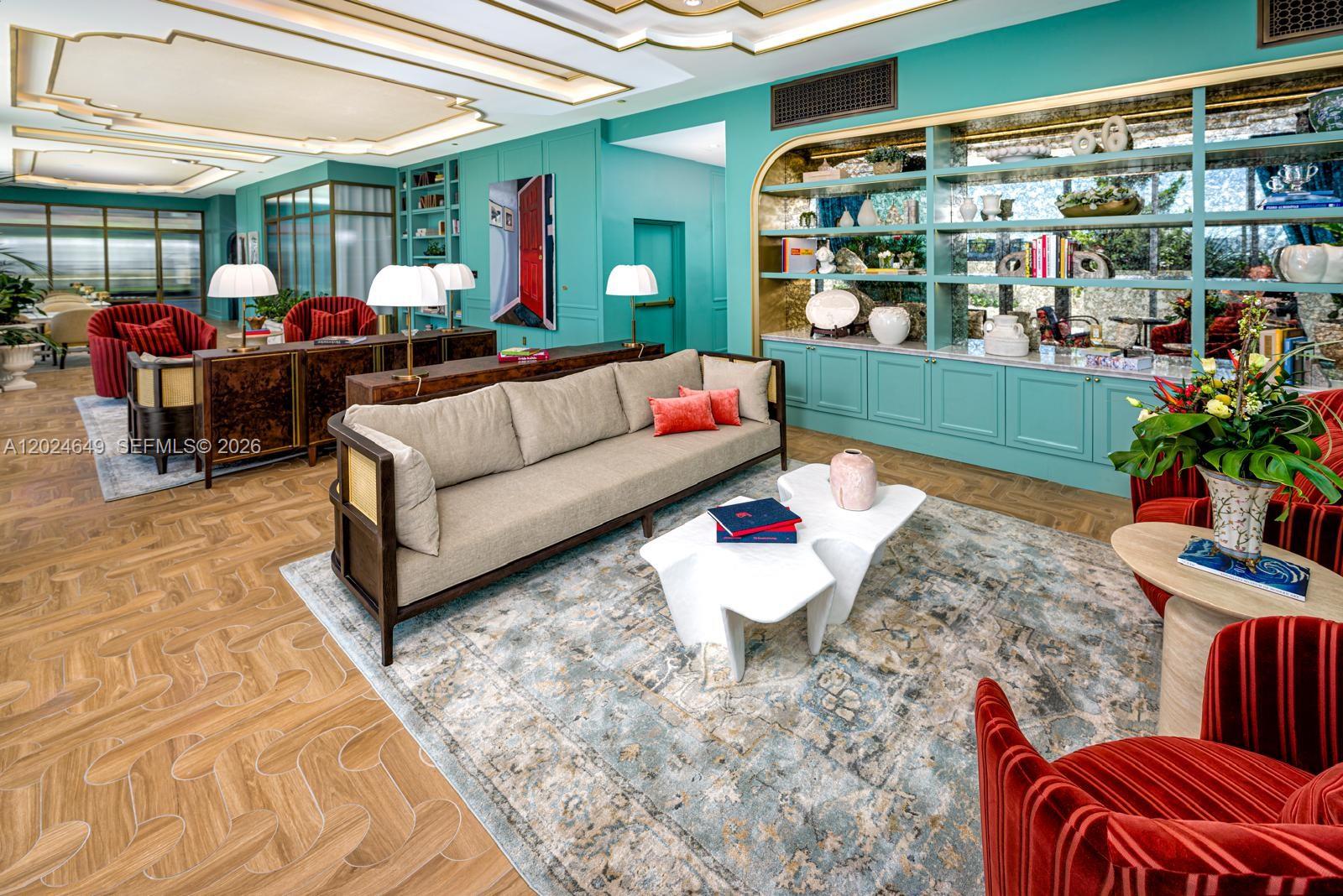 A living room features teal walls, built-in shelving, a beige sofa, and red velvet armchairs — 2700 NW 2nd Ave # 233, Miami FL 33127, MIAMI, FL