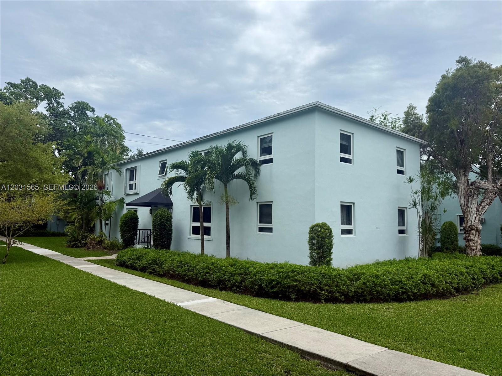 A two-story light blue apartment building features palm trees and a sidewalk in the foreground — 7715 SW 57th Ave # 3, Miami FL 33143, MIAMI, FL