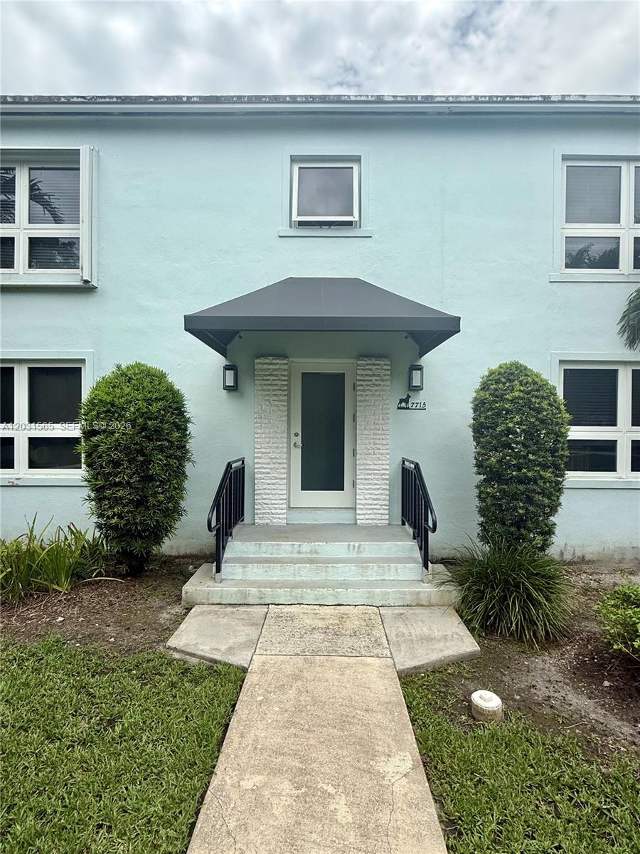 A light blue two-story building features a central entrance with a dark awning and steps — 7715 SW 57th Ave # 3, Miami FL 33143, MIAMI, FL