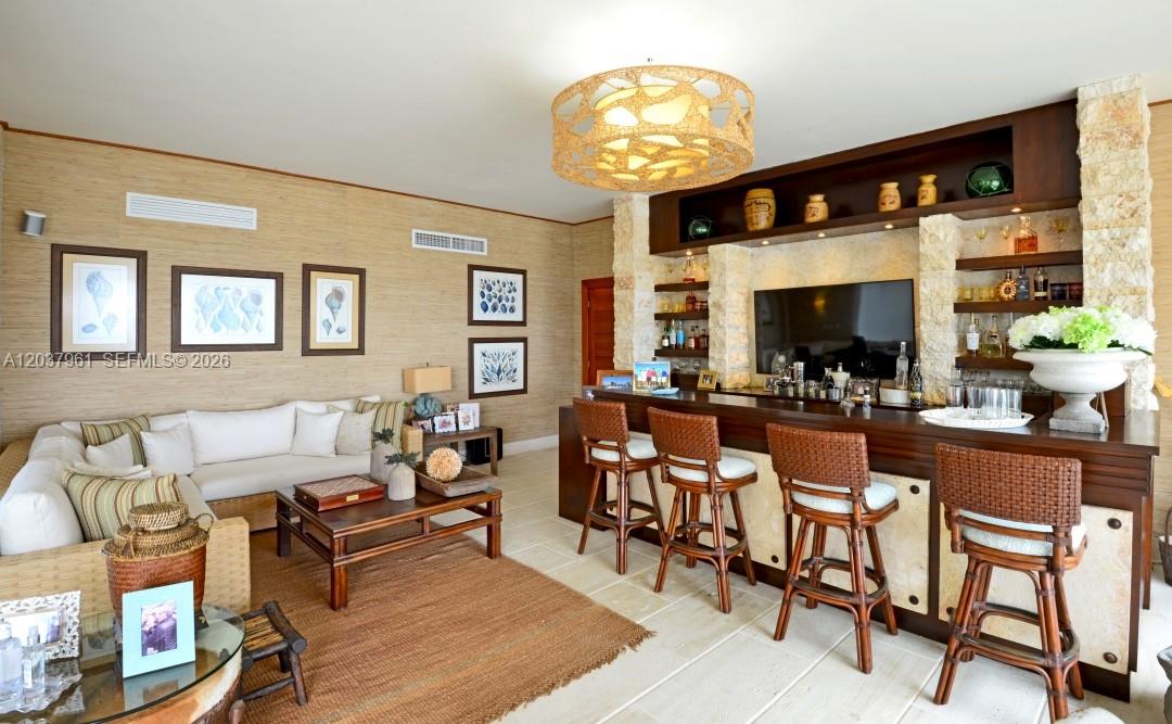 A living room features a built-in bar, rattan stools, and textured wallpaper — 0 Juanillo Bay, FL