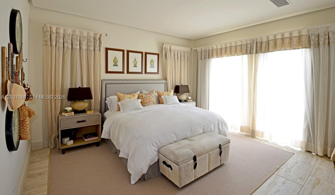 A bedroom features a king bed, a storage bench, nightstands, and floor-to-ceiling curtains — 0 Juanillo Bay, FL