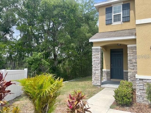 A view of a house exterior featuring a stone-accented entryway and a dark front door — 833 WILTONWAY DRIVE, PLANT CITY, FL
