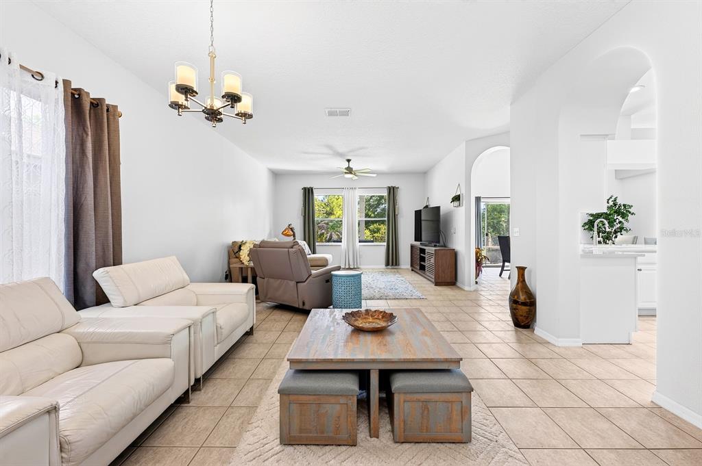 A living room features white leather sofas, a wooden coffee table, and tile flooring — 14933 YORKSHIRE RUN DRIVE, ORLANDO, FL