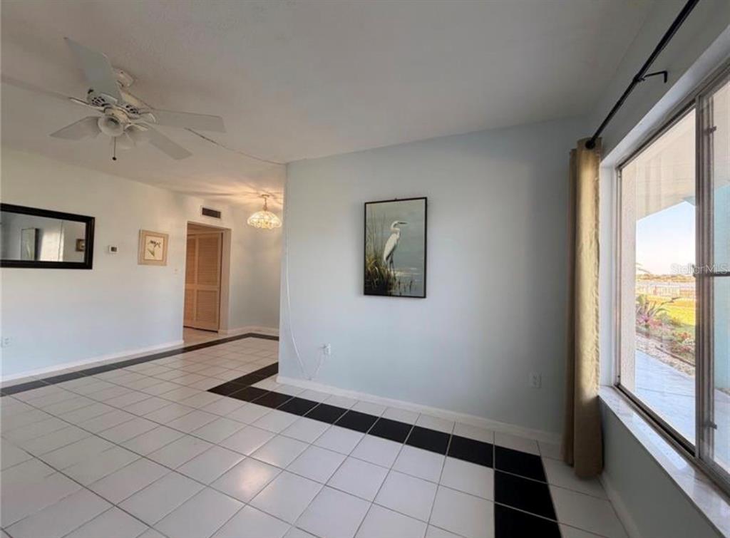 An interior view of a room with white tiled floors featuring black accent borders — 3009 N HALIFAX AVENUE UNIT 2, DAYTONA BEACH, FL