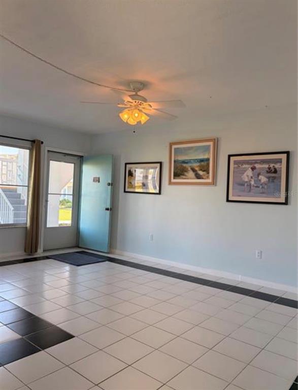 A bright room features white tiled floors, a ceiling fan, and three framed pictures on the wall — 3009 N HALIFAX AVENUE UNIT 2, DAYTONA BEACH, FL