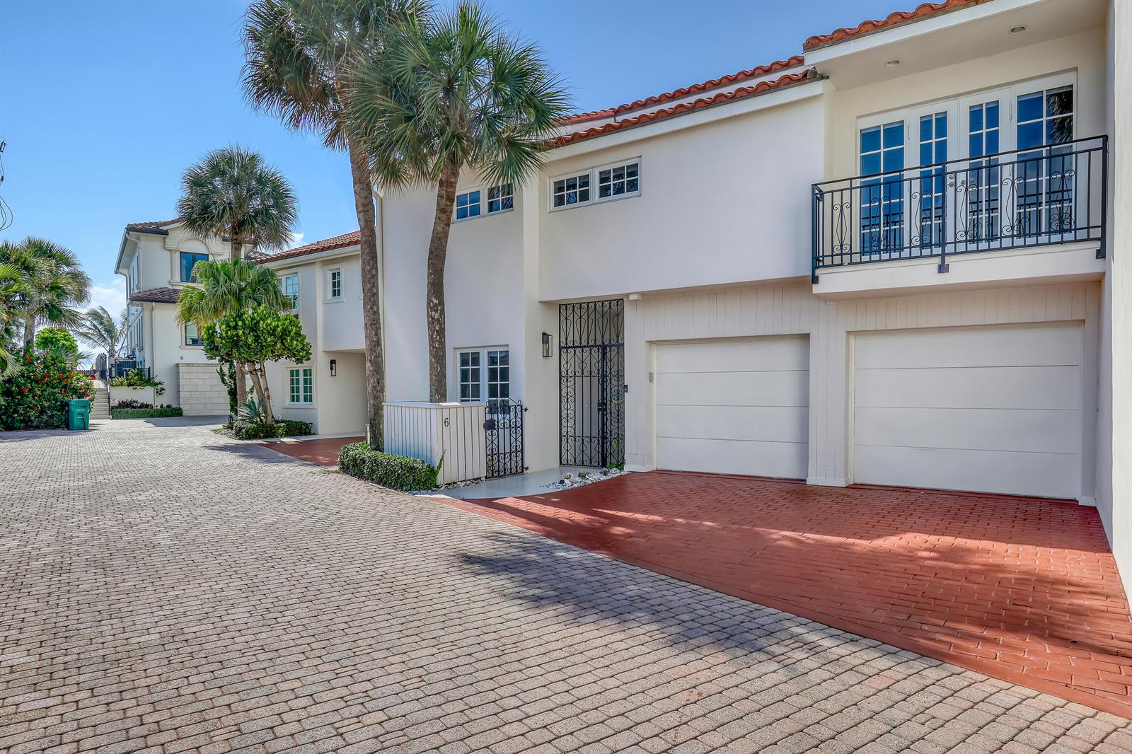 A two-story white townhouse with a two-car garage, balcony, and brick-paved driveway — 220 Celestial Way # 6, Juno Beach FL 33408, JUNO BEACH, FL
