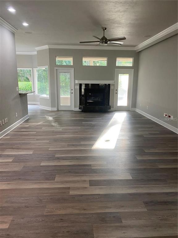 A living room with gray walls, wood-look flooring, a fireplace, and glass doors to outside — 4072 NW 37TH TERRACE, GAINESVILLE, FL