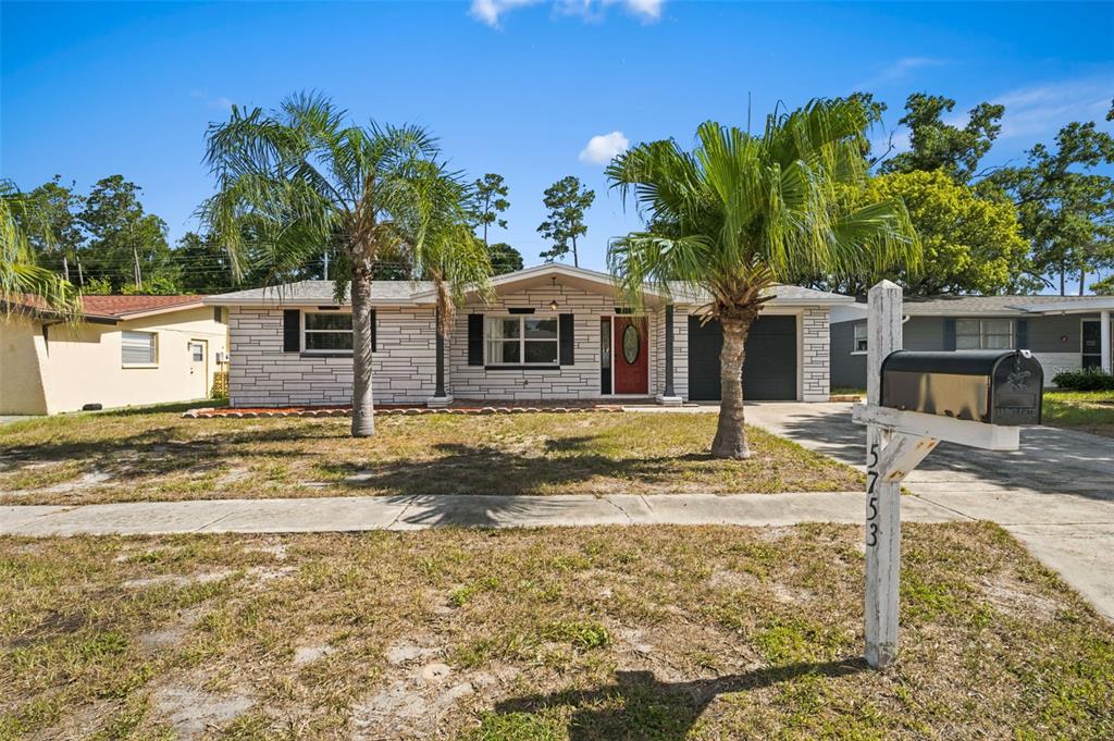 A single-story house with a stone facade, two palm trees, and a mailbox in front — 5753 1ST AVENUE, NEW PORT RICHEY, FL