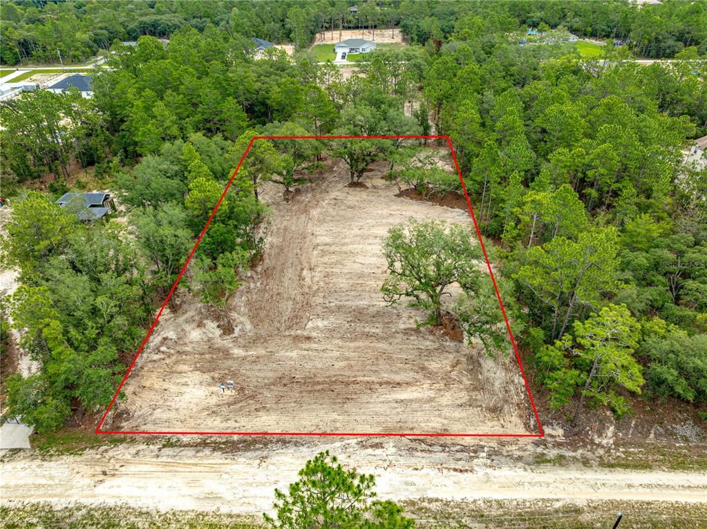 An aerial view shows a cleared, rectangular residential lot surrounded by trees and vegetation — TBD SW 125 TERRACE, DUNNELLON, FL