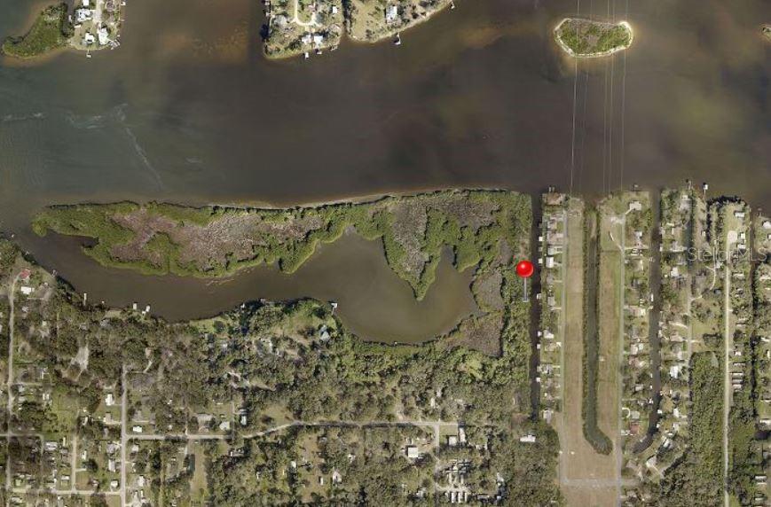 An aerial view shows a waterfront property lot marked with a red pin near mangroves — 7610 ANNA AVENUE, GIBSONTON, FL