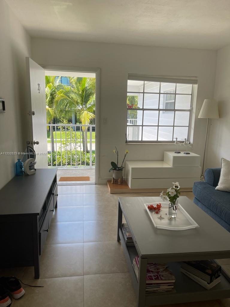 A living room with tile floors, a coffee table, and an open door to a balcony — 100 Sunrise Dr # 25, Key Biscayne FL 33149, KEY BISCAYNE, FL