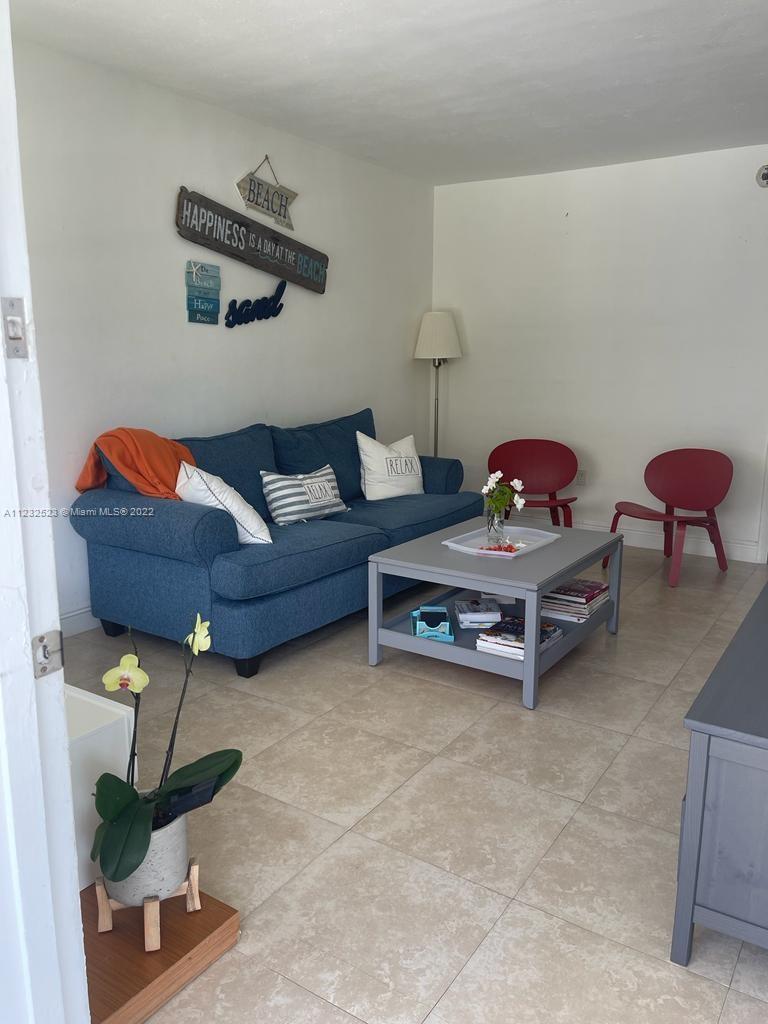 A living room features a blue sofa, a grey coffee table, and two red chairs — 100 Sunrise Dr # 25, Key Biscayne FL 33149, KEY BISCAYNE, FL