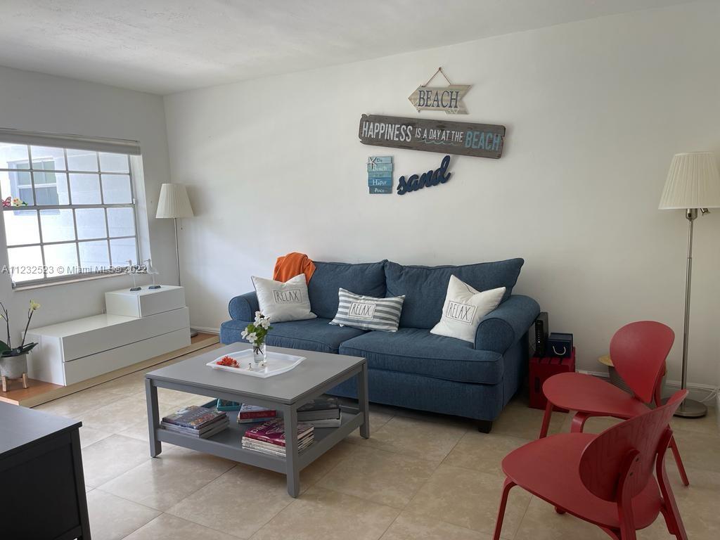 A living room features a blue sofa, a gray coffee table, and two red chairs — 100 Sunrise Dr # 25, Key Biscayne FL 33149, KEY BISCAYNE, FL