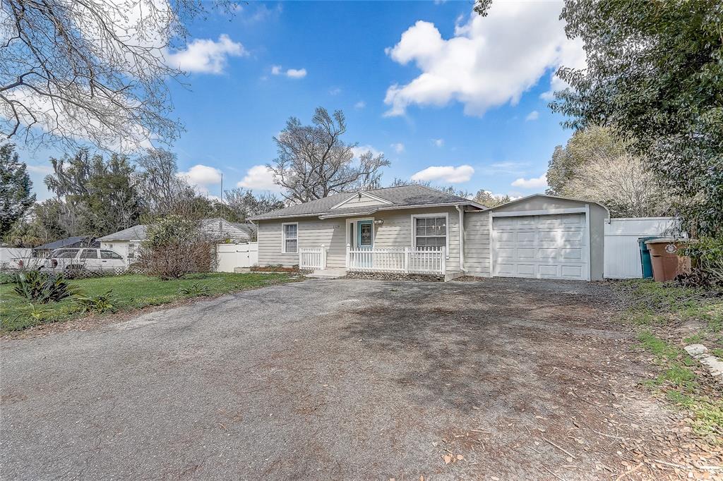A single-story house with light siding, a front porch, and an attached garage — 1129 NE 12TH STREET, OCALA, FL