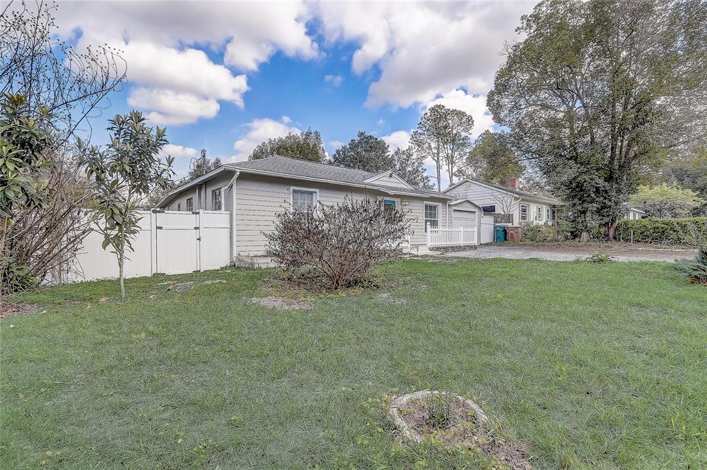 A single-story house with light gray siding and a white fence sits on a lawn — 1129 NE 12TH STREET, OCALA, FL