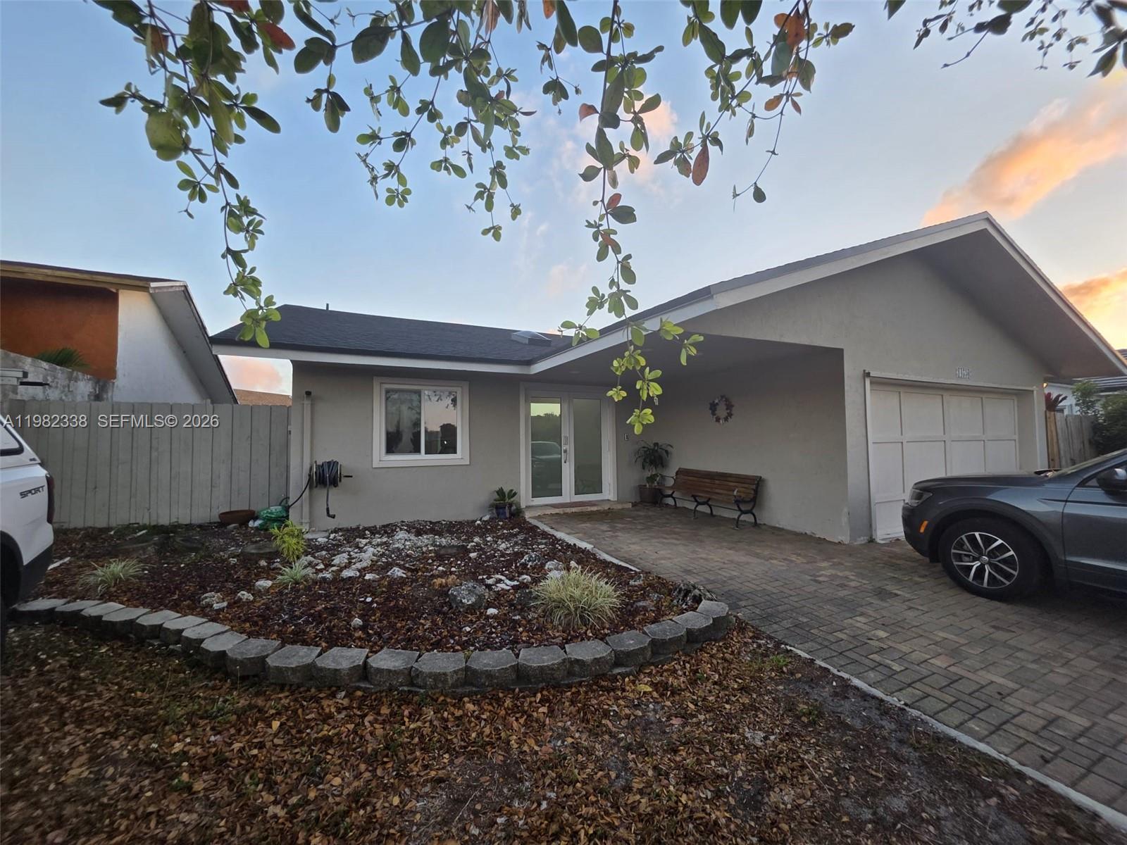 A single-story house features a gray exterior, a paved driveway, and a small front garden — 14530 SW 110th St, Miami FL 33186, MIAMI, FL