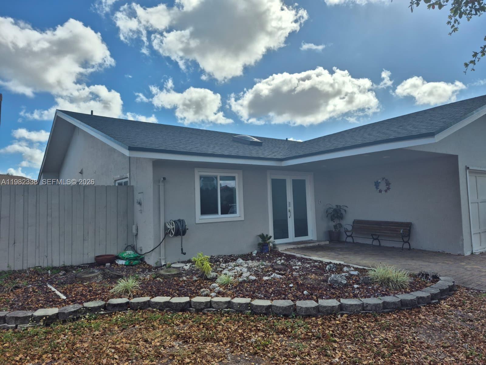 A single-story house with a gray exterior, a covered entryway, and a landscaped front yard — 14530 SW 110th St, Miami FL 33186, MIAMI, FL