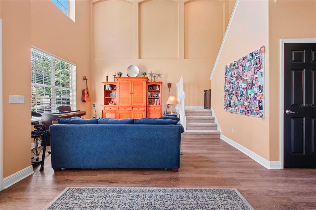 A dining room features a dark wood table, patterned chairs, white wainscoting, and peach walls — 14332 SOUTHERN RED MAPLE DRIVE, ORLANDO, FL