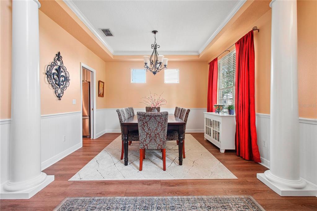 A living room features a brown sectional sofa, a colorful area rug, and a bookshelf — 14332 SOUTHERN RED MAPLE DRIVE, ORLANDO, FL