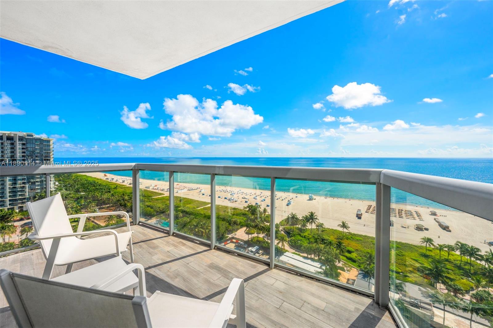 A balcony with two white chairs overlooks a sandy beach and the ocean — 101 20th St # 2007, Miami Beach FL 33139, MIAMI BEACH, FL
