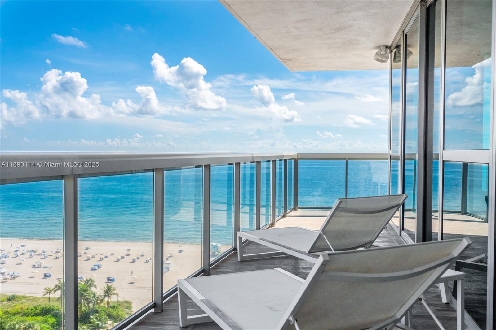A balcony with two lounge chairs overlooks a sandy beach and the ocean — 101 20th St # 2007, Miami Beach FL 33139, MIAMI BEACH, FL