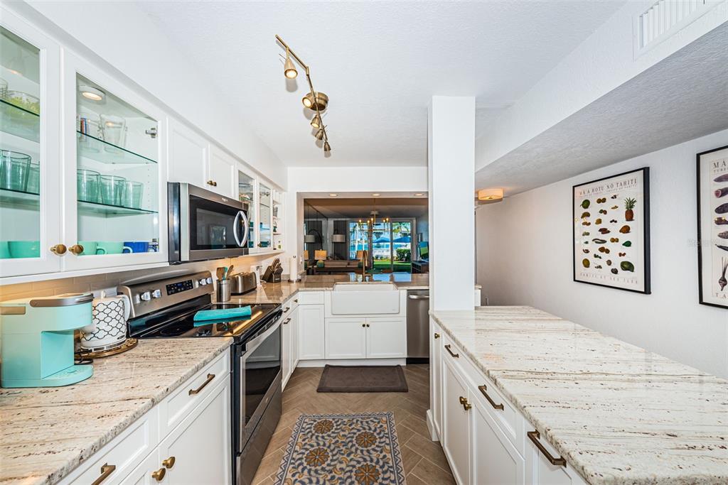 A kitchen with white cabinets, granite countertops, stainless steel appliances, and a view of outdoors — 5901 BAHIA DEL MAR CIRCLE UNIT 122, ST PETERSBURG, FL