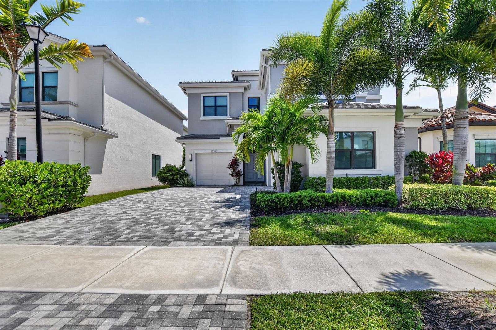 A two-story suburban house with a paved driveway, palm trees, and a manicured lawn — 17358 Santaluce Manor, Boca Raton FL 33496, BOCA RATON, FL
