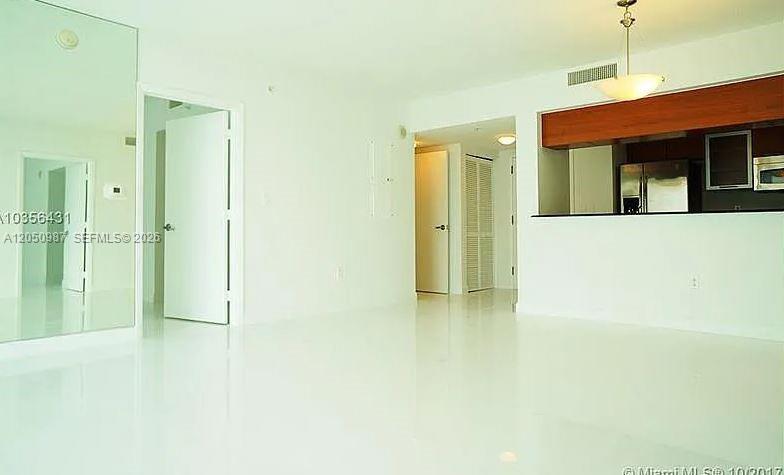 An interior view of a room with white walls, glossy floors, and a kitchen pass-through — 1800 N Bayshore Dr # 3014, Miami FL 33132, MIAMI, FL