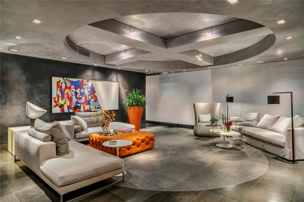 A modern living room features a circular ceiling cutout, gray stone flooring, and orange furniture — 1800 MCLEARY UNIT PH 2, SAN JUAN, PR