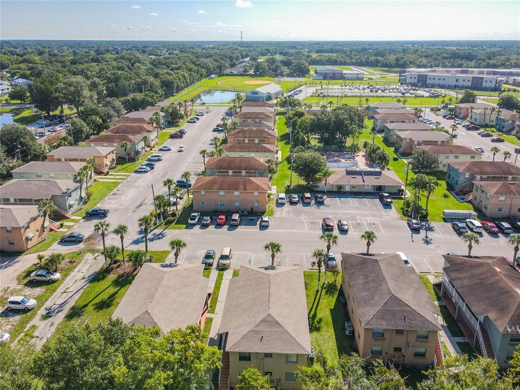 An aerial view of a multi-building apartment complex with parking lots and surrounding green space — 714 MICHIGAN COURT UNIT 4, ST CLOUD, FL