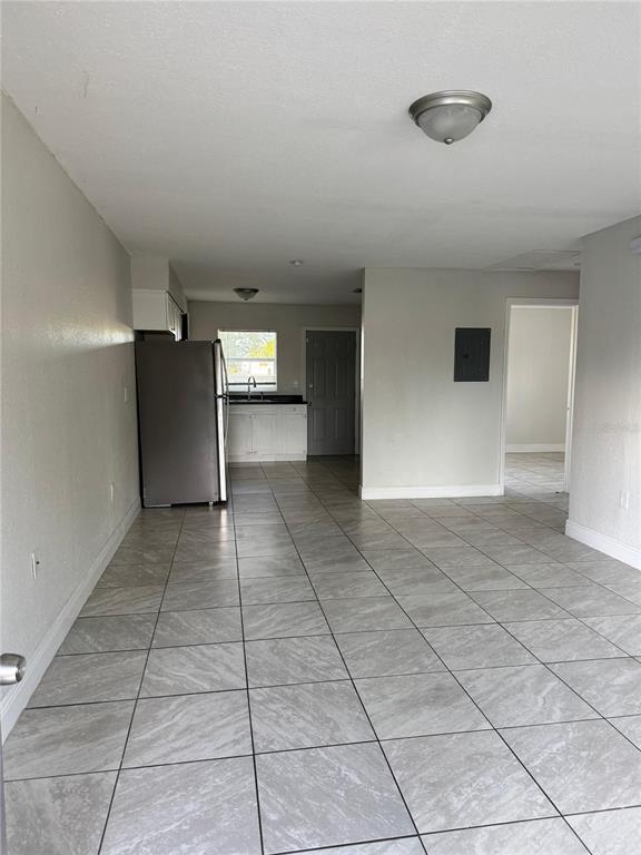 A view of a kitchen and living area with light gray tile flooring — 1112 MARTIN STREET UNIT C, HAINES CITY, FL