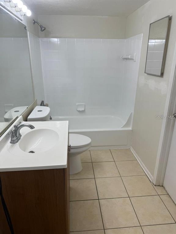 A bathroom features a white vanity, a toilet, and a tiled tub-shower combination — 1972 LAKE ATRIUMS CIRCLE UNIT 187, ORLANDO, FL