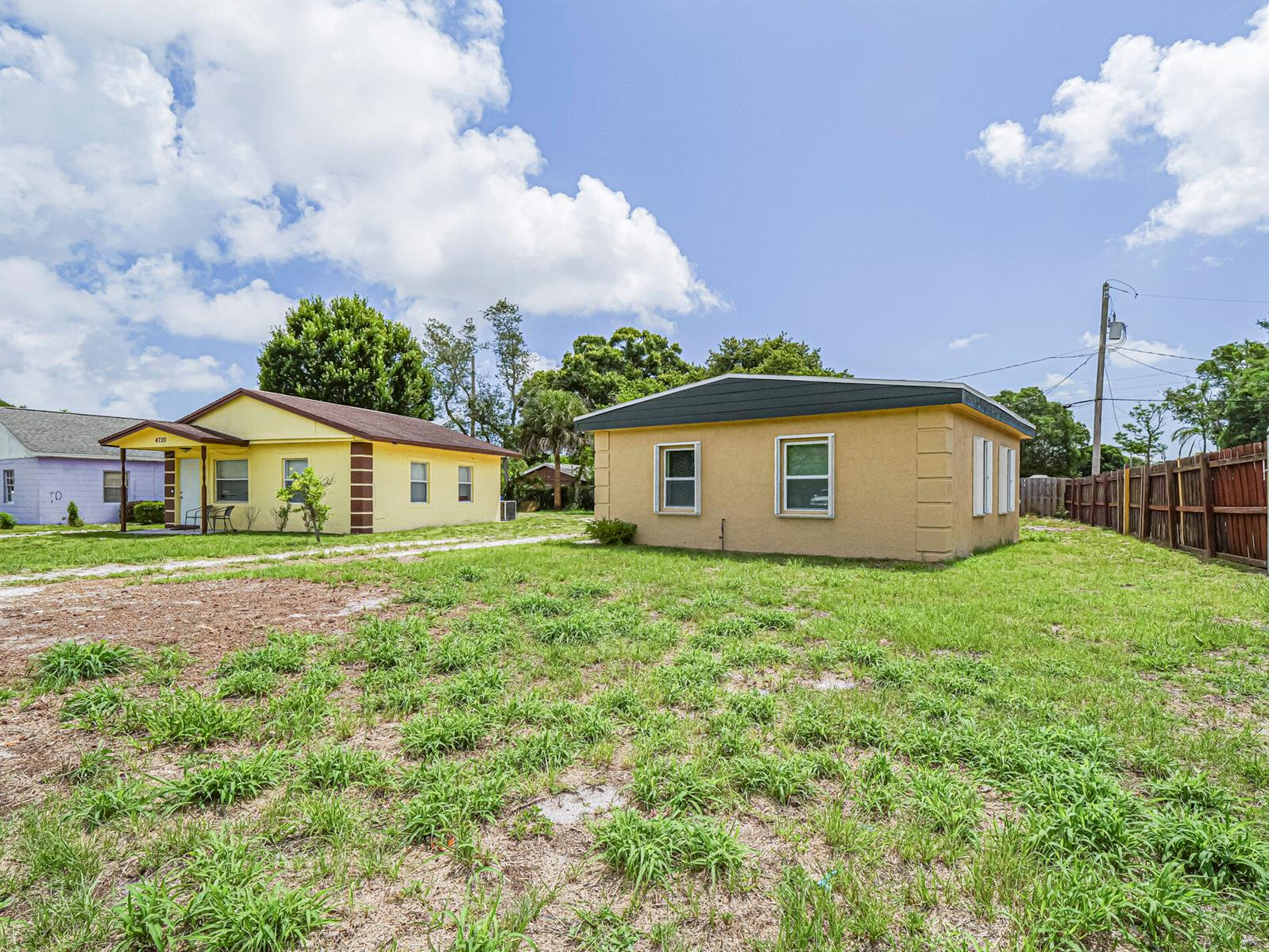 Two single-story houses stand on a grassy lot under a blue sky with clouds — 4716 29th Avenue, Vero Beach FL 32967, VERO BEACH, FL