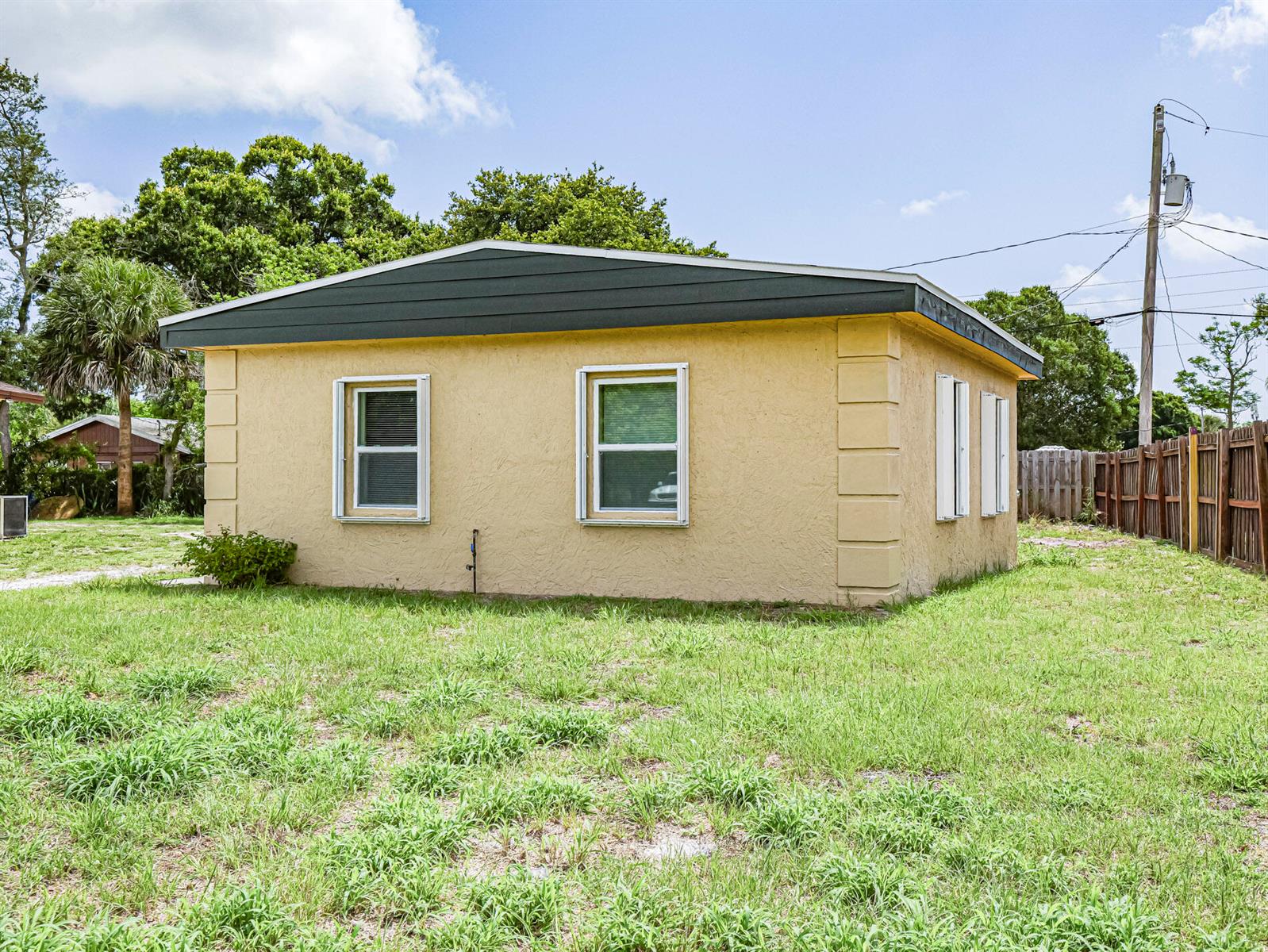 A yellow, single-story detached building with a dark roof sits on a grassy lot — 4716 29th Avenue, Vero Beach FL 32967, VERO BEACH, FL