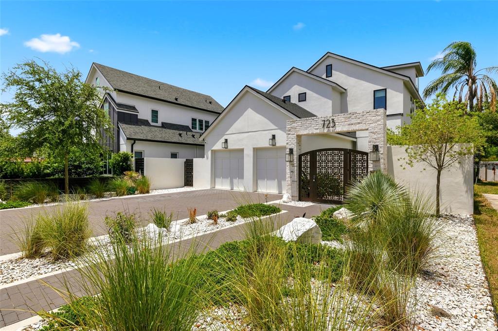 A modern two-story house with a two-car garage, stone entryway, and landscaped front yard — 723 SYMONDS AVENUE, WINTER PARK, FL