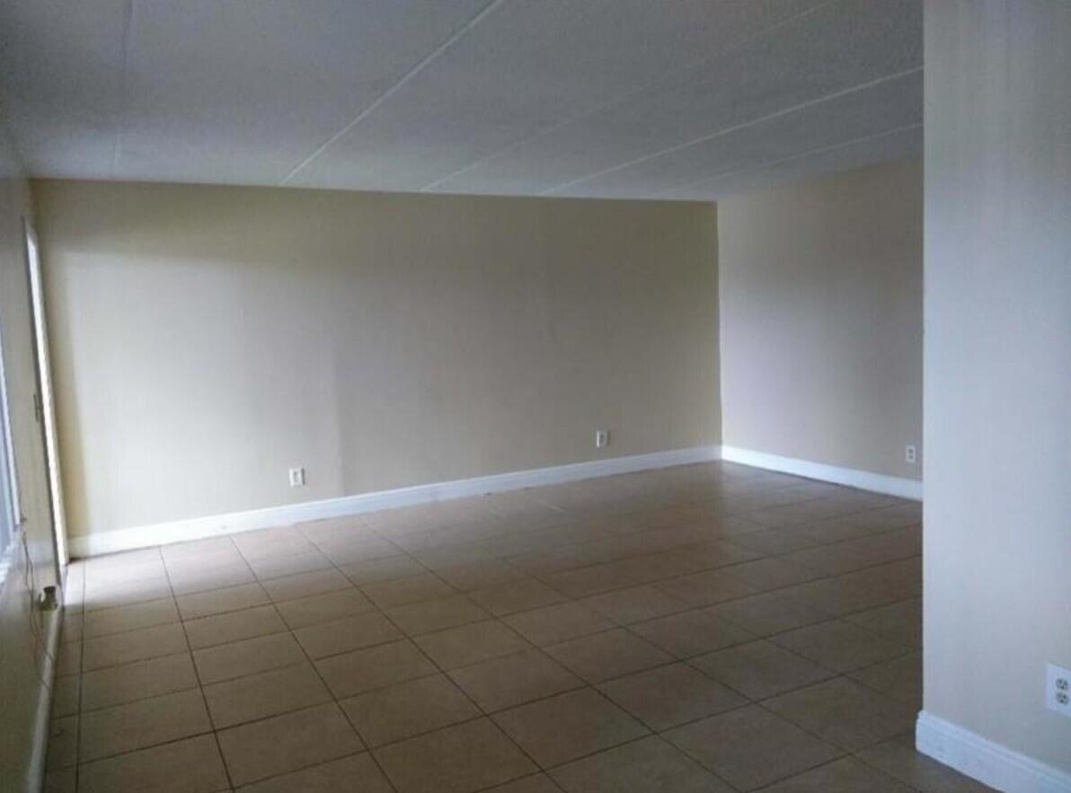 An empty room with beige walls and light-colored tile flooring — 1205 Meadows Circle, Boynton Beach FL 33436, BOYNTON BEACH, FL