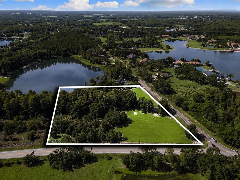 An aerial view shows a large, partially wooded rectangular plot of land bordering a road — 18117 BOY SCOUT ROAD, ODESSA, FL