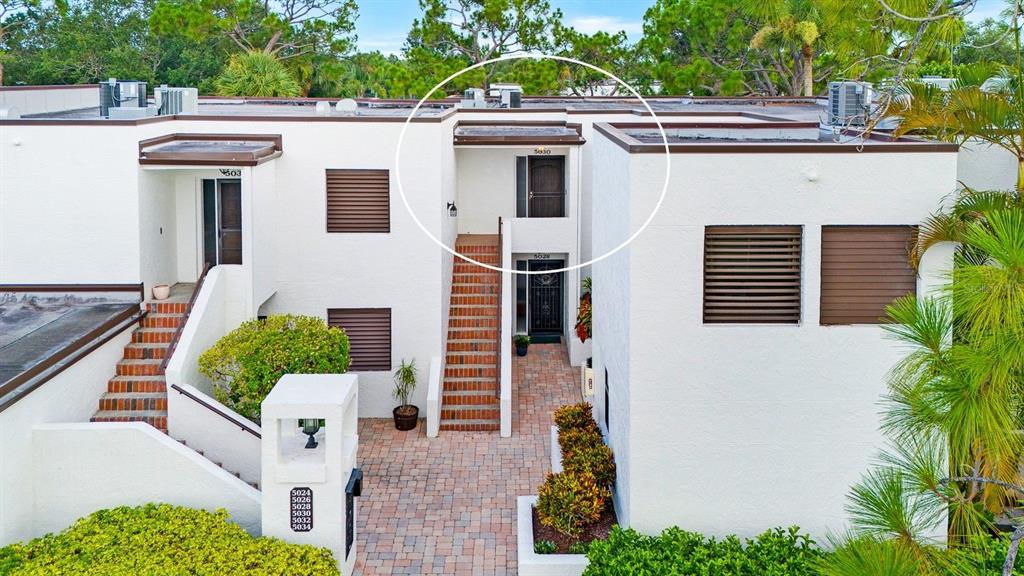 An exterior view of a two-story apartment building with a circled upper-level entrance door — 5030 MARSH FIELD ROAD UNIT 22, SARASOTA, FL
