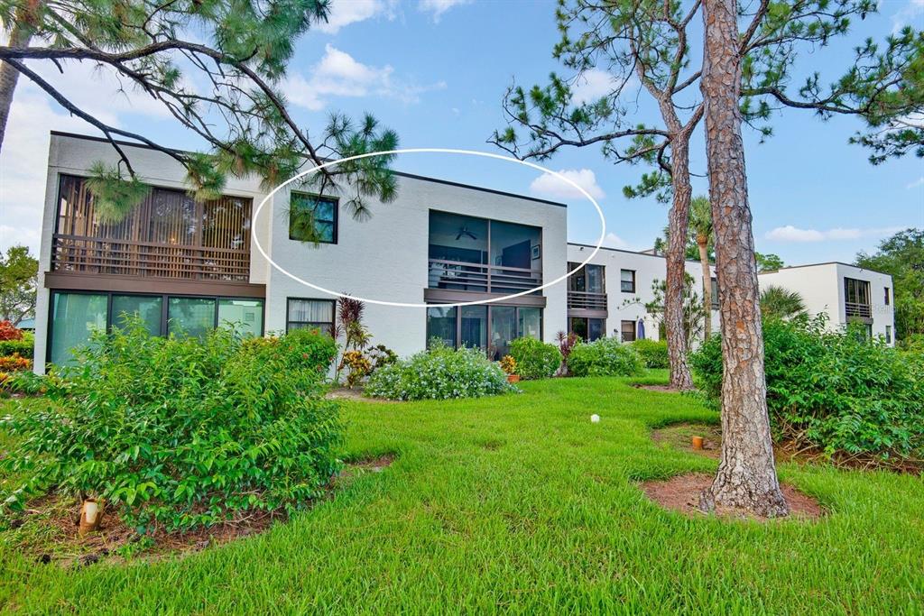 The exterior of a multi-story residential building featuring a screened-in balcony on the upper level — 5030 MARSH FIELD ROAD UNIT 22, SARASOTA, FL
