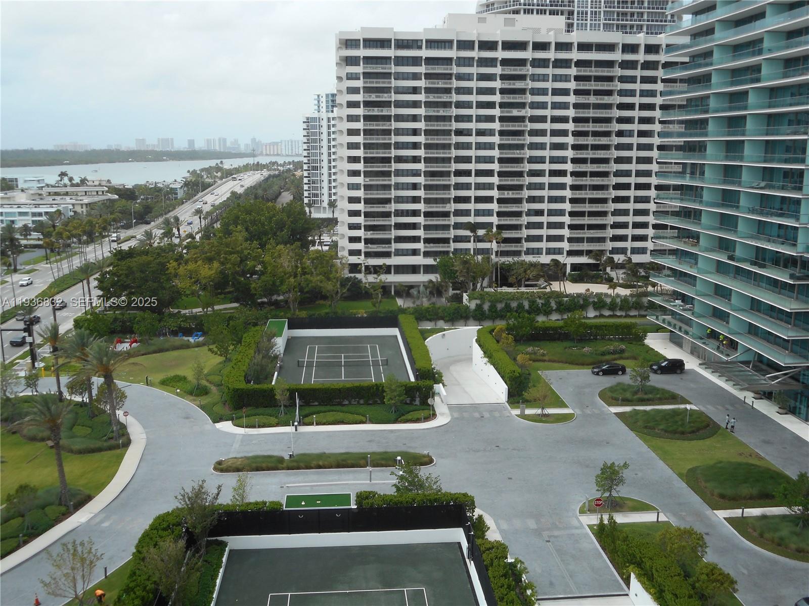 An elevated view shows two tennis courts, a paved driveway, and surrounding apartment buildings — 10185 Collins Ave # 1204, Bal Harbour FL 33154, BAL HARBOUR, FL
