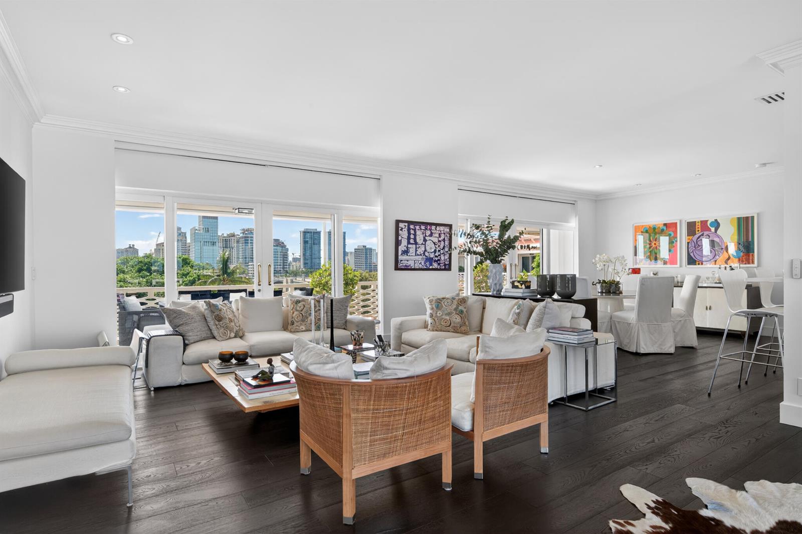 A bright living room features dark wood floors, white sofas, and a view of city buildings — 315 S Lake Drive # D, Palm Beach FL 33480, PALM BEACH, FL