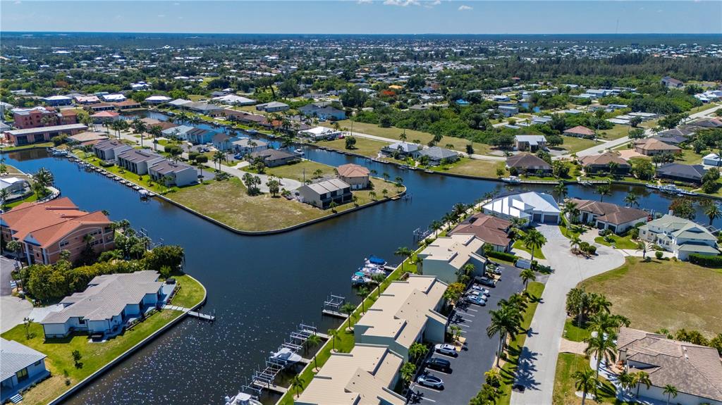 An aerial view shows waterfront residential buildings, boat docks, and a canal in Florida — 1400 MINEO DRIVE UNIT 12T, PUNTA GORDA, FL