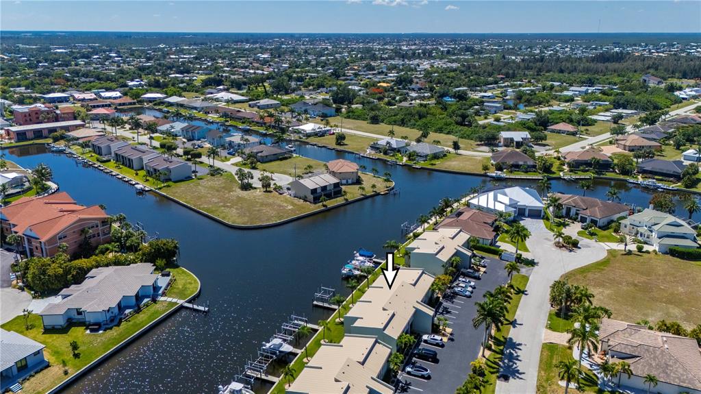 An aerial view shows a waterfront residential complex with boat slips and a parking lot — 1400 MINEO DRIVE UNIT 12T, PUNTA GORDA, FL