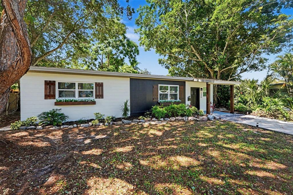 A single-story house with white and dark gray siding, window boxes, and a front porch — 340 55TH AVE S, ST PETERSBURG, FL