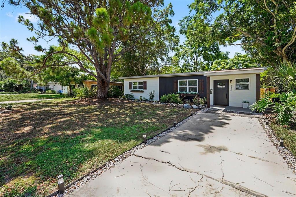 A single-story house with a white and dark gray exterior sits behind a concrete driveway — 340 55TH AVE S, ST PETERSBURG, FL